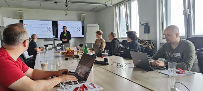 Seven attendees at IndieWebCamp inside a large conference room at CGI Düsseldorf