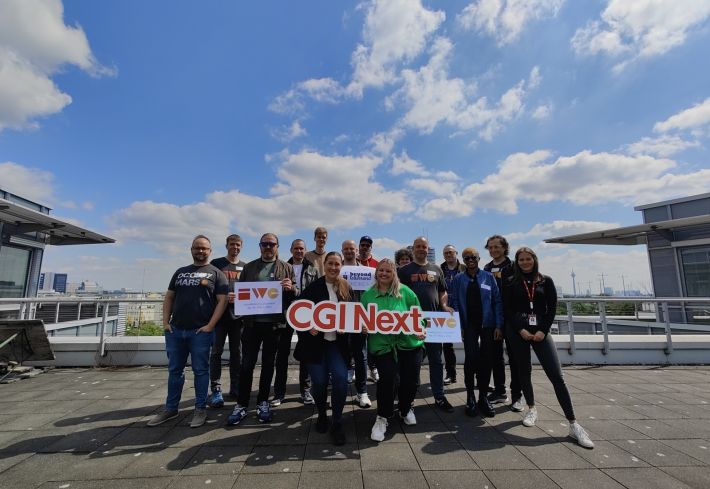 15 attendees of IWC Düsseldorf on roof terrace of CGI with cityscape behind