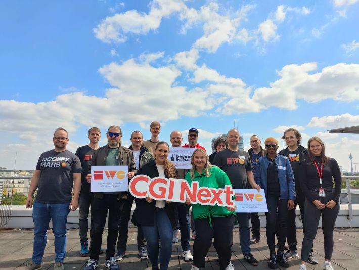 15 attendees of IWC Düsseldorf on roof terrace of CGI with cityscape behind