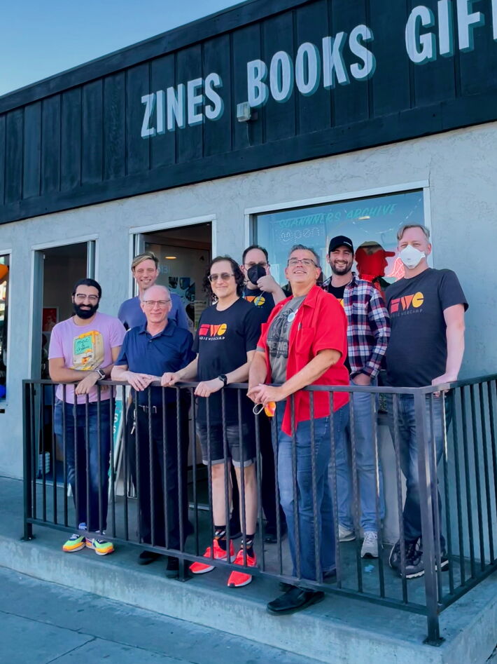 8 people standing in front of a storefront.